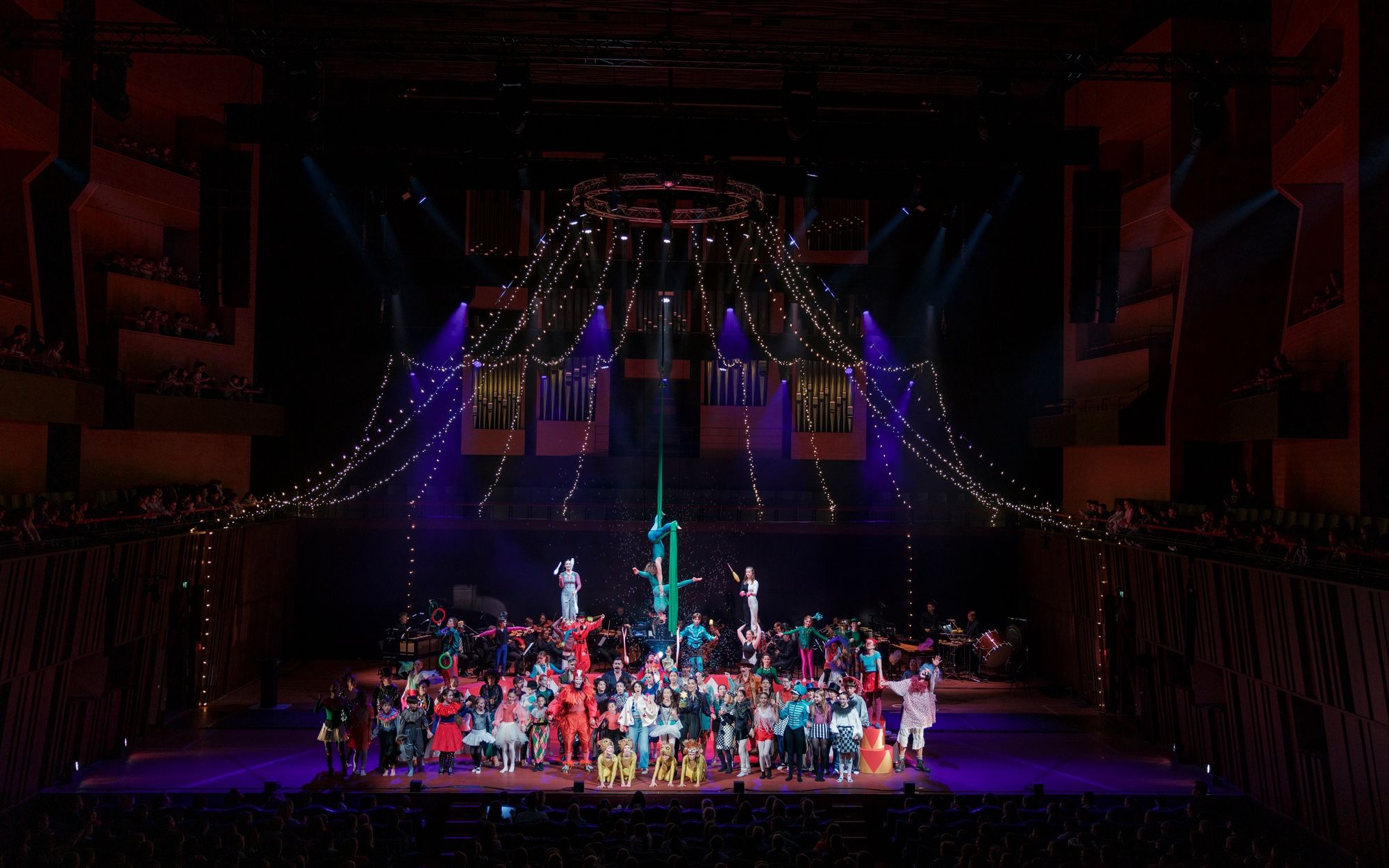 Acrobats on a pole above the ensemble in the ring, the circus tent built into the concert hall.