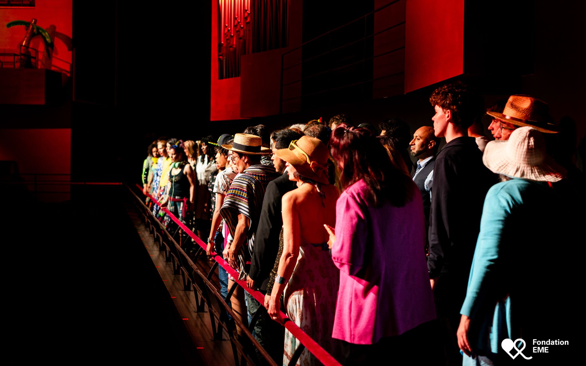 Costumed participants move through the audience along a red barrier.